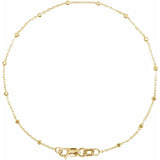 A gold-colored bracelet featuring a series of faceted beads strung on a cable chain.
