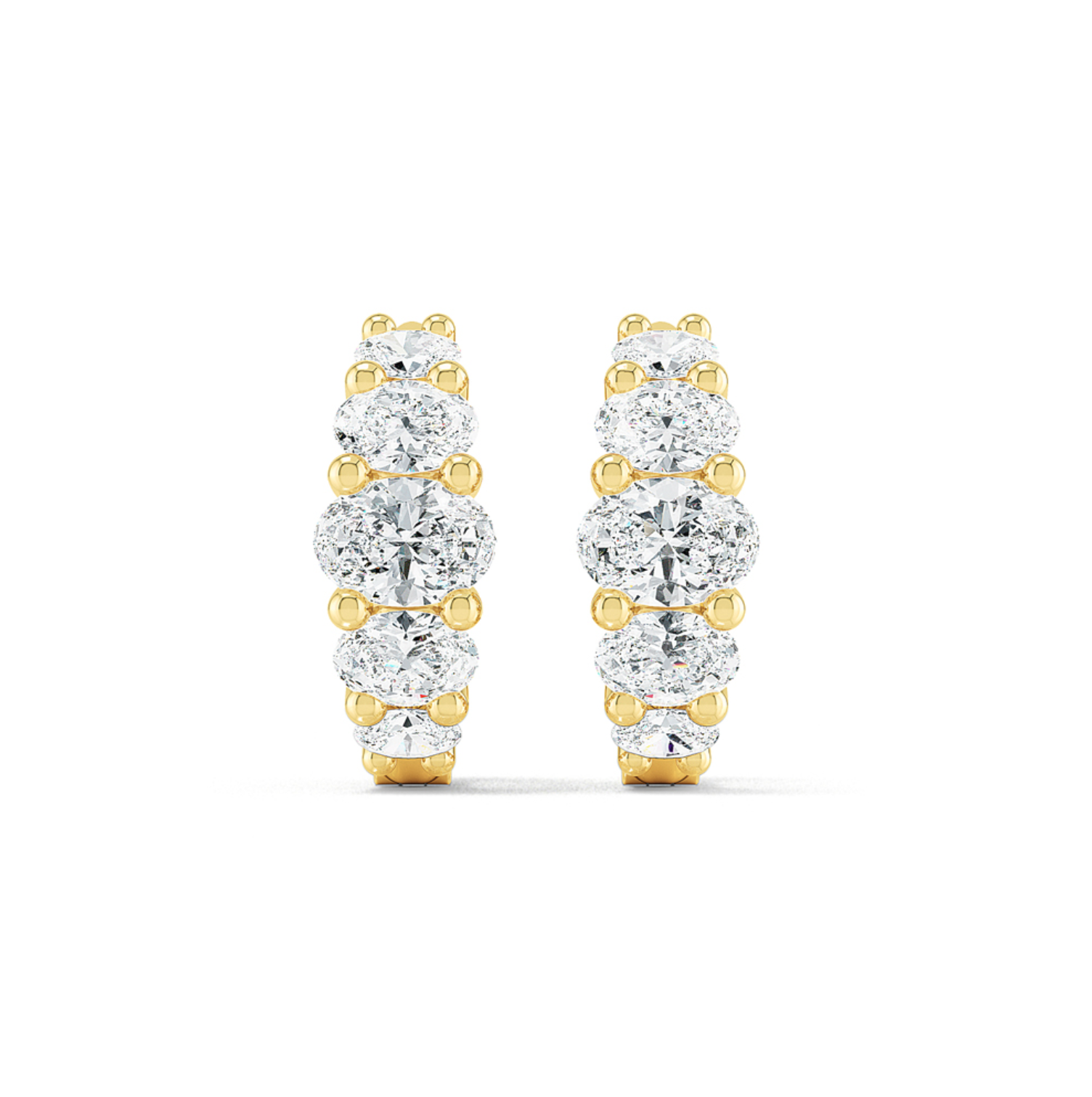 A pair of oval huggie earrings featuring multiple diamond cuts, set in either white or yellow gold.