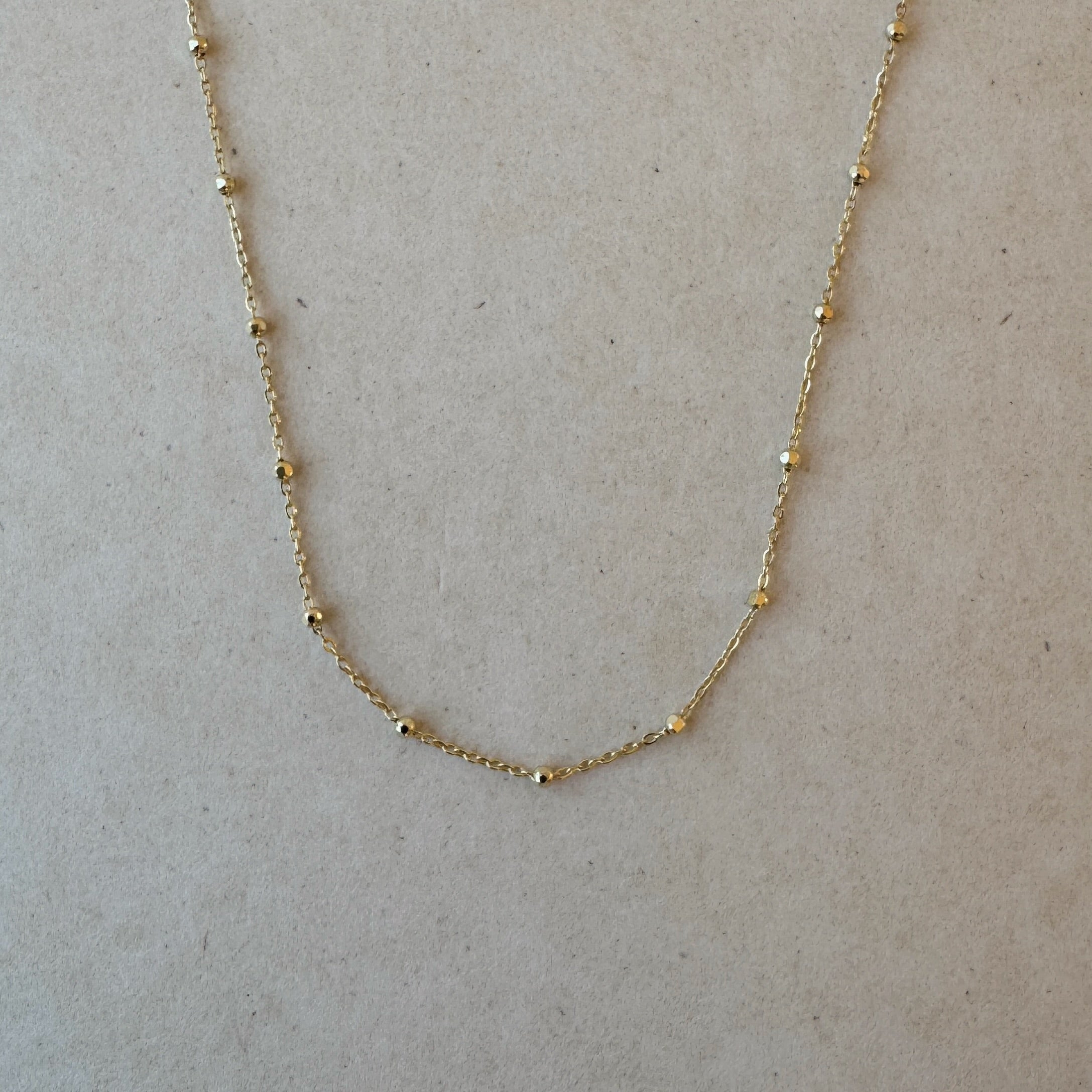 Close-up of Beaded Cable Necklace in 14ct gold showing faceted bead detail