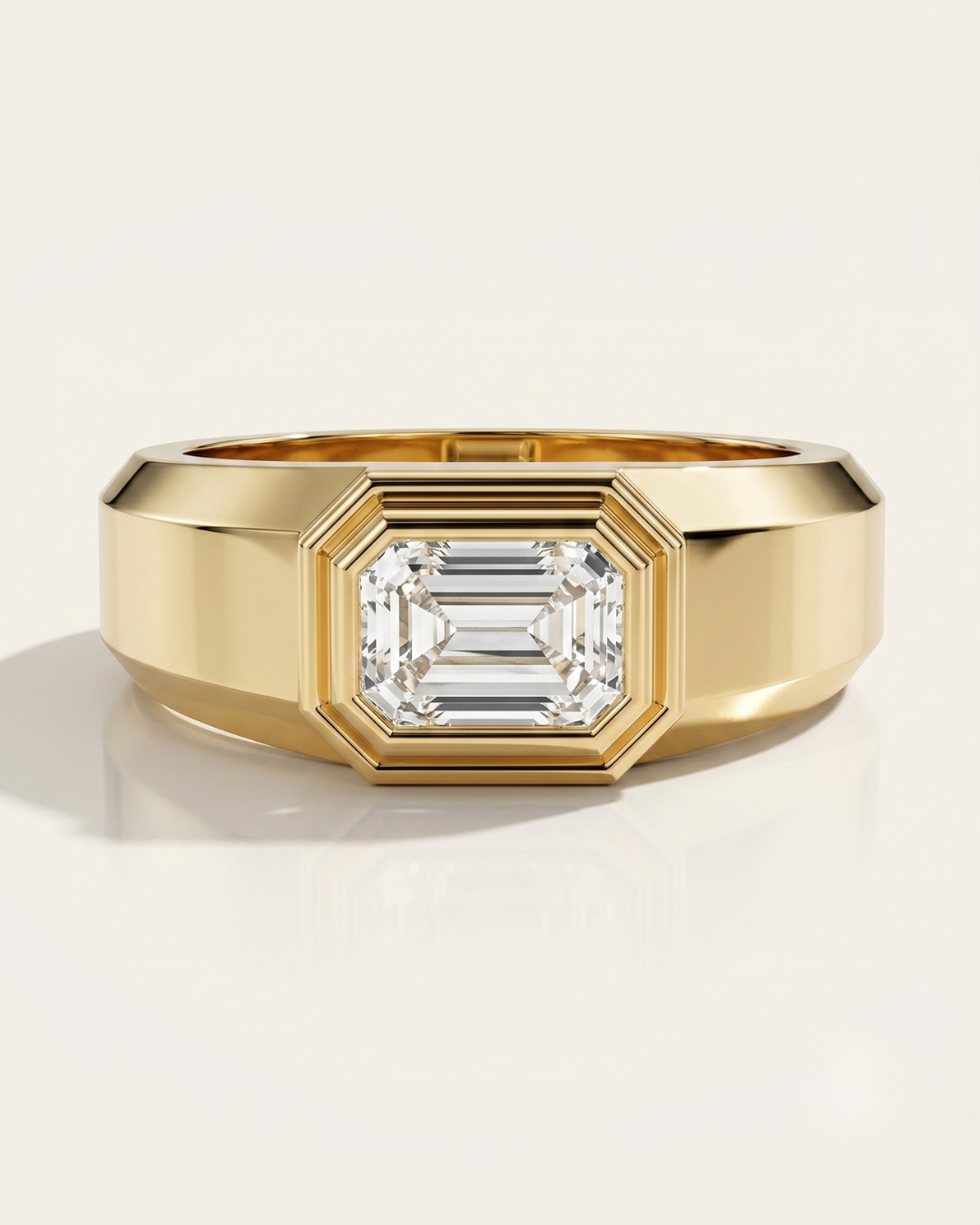 Wide men's solid yellow gold ring featuring a horizontally set (East-West) emerald-cut diamond in a thick, architectural bezel setting.