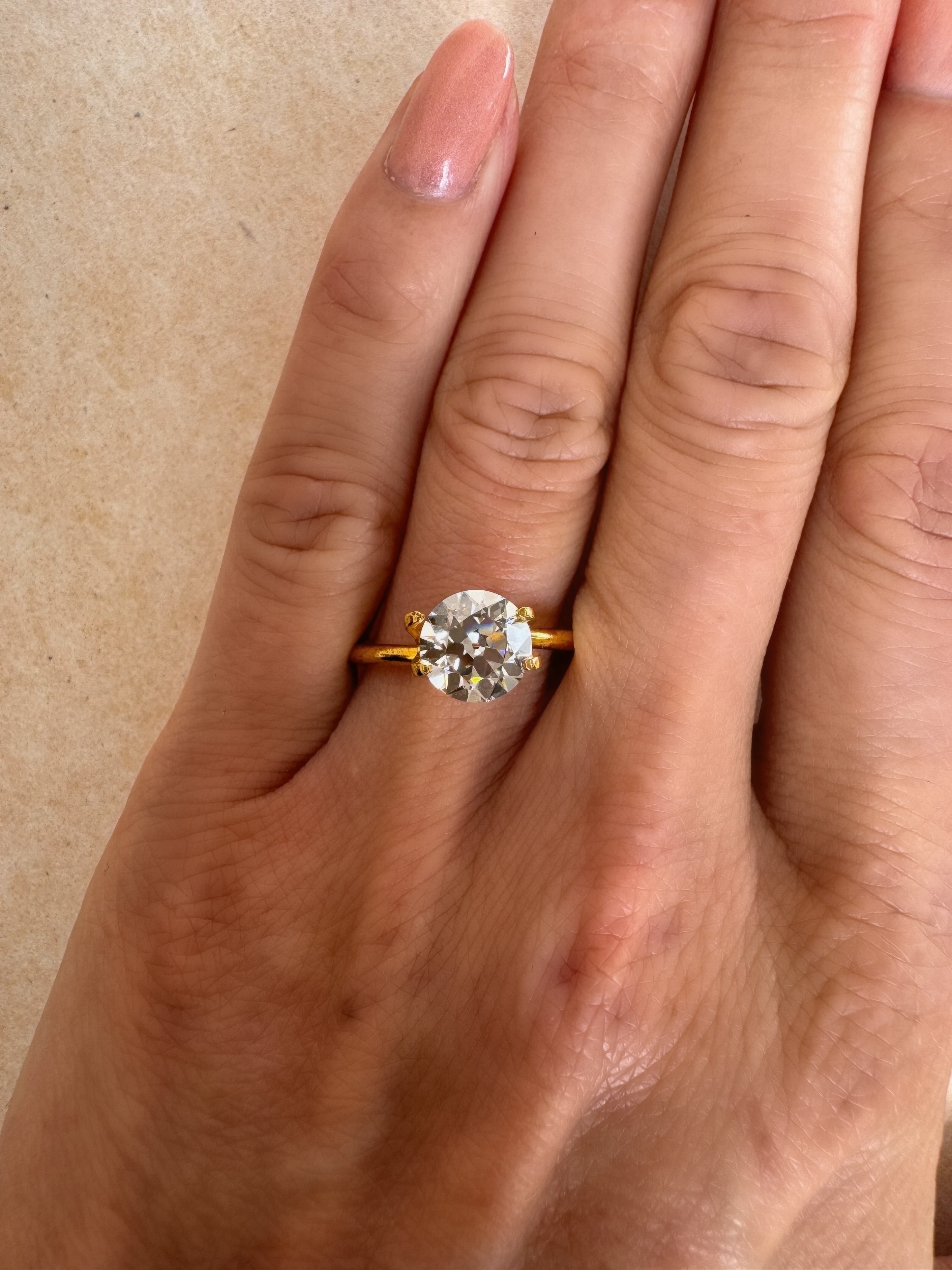 Close-up of a 1.52 carat Old European cut lab-grown diamond set in a yellow gold solitaire ring on a hand. Showcasing custom engagement ring designs available at MOHSTEN in Auckland, NZ.