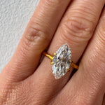 Close-up of the actual 2.01 carat marquise cut lab diamond held in a temporary yellow gold setting on a hand, showcasing its true size and brilliant E colour. Available for custom architectural ring commissions at MOHSTEN in Auckland, NZ.