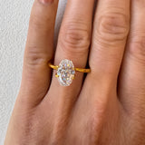 A hand wearing a yellow gold engagement ring featuring a 2.09ct oval step cut lab diamond. A bespoke ring design concept by MOHSTEN jewellery studio in Auckland, New Zealand.