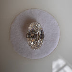 A loose 2.09ct oval step cut lab-grown diamond resting flat on a round white felt pad. Sourced for bespoke custom engagement rings by MOHSTEN jewellery studio in Auckland, New Zealand.
