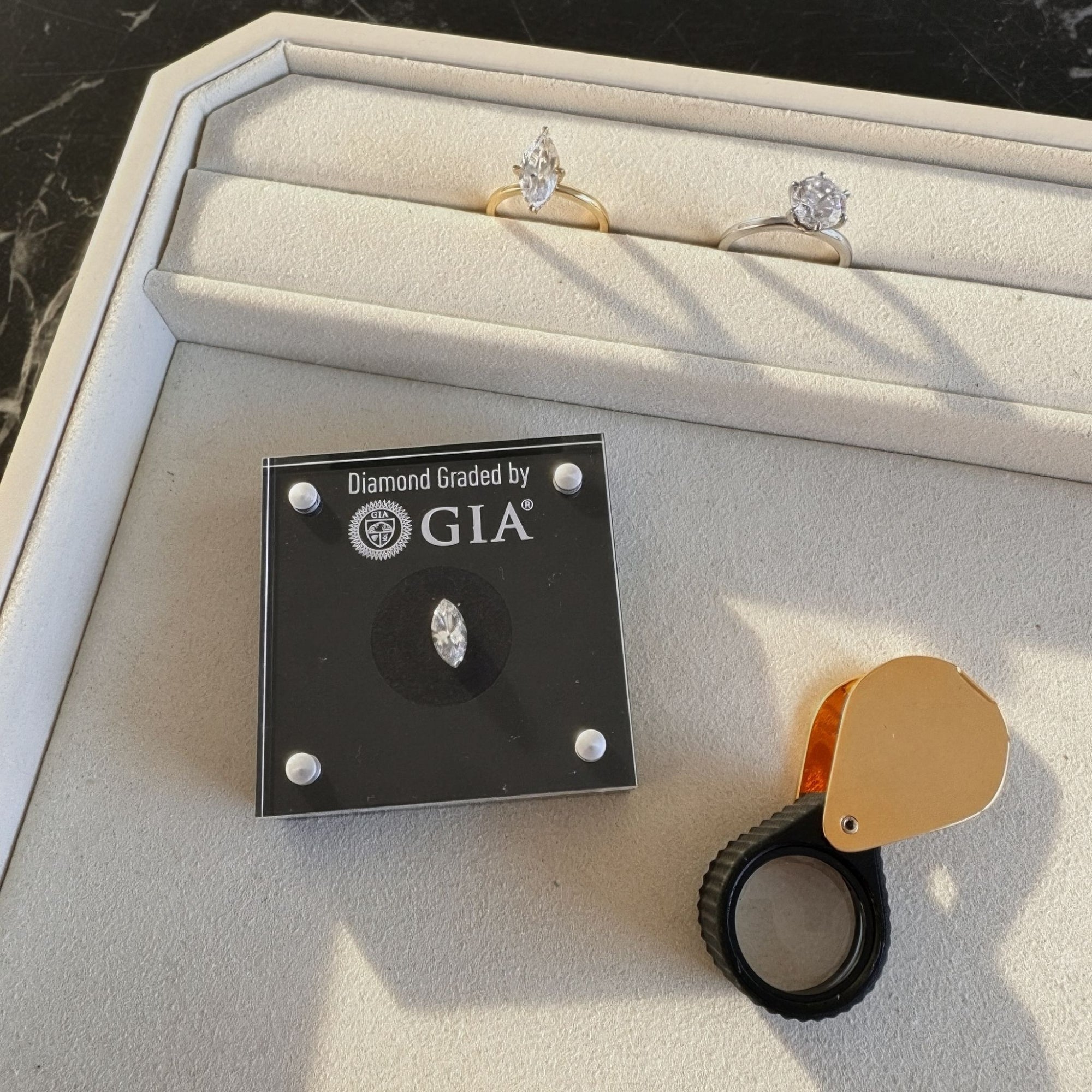 loup with GIA logo on a diamond display case. 4c's Diamond guide by MOHSTEN jewellery