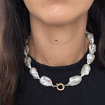 Close-up of the MOHSTEN Baroque Pearl Necklace resting on a black collar, highlighting the 13mm freshwater pearls and the solid 9ct yellow gold 12mm bolt ring clasp.
