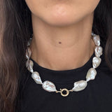 Close-up of the MOHSTEN Baroque Pearl Necklace resting on a black collar, highlighting the 13mm freshwater pearls and the solid 9ct yellow gold 12mm bolt ring clasp.