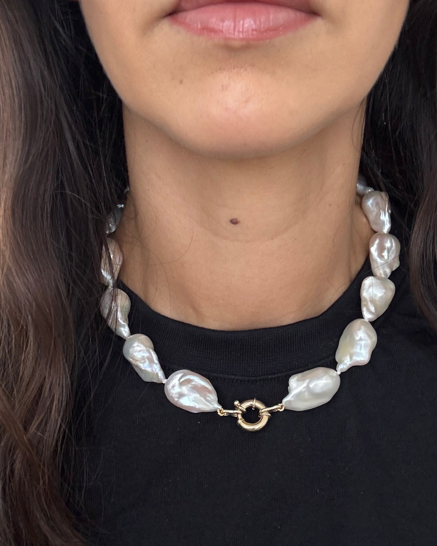 Close-up of the MOHSTEN Baroque Pearl Necklace resting on a black collar, highlighting the 13mm freshwater pearls and the solid 9ct yellow gold 12mm bolt ring clasp.