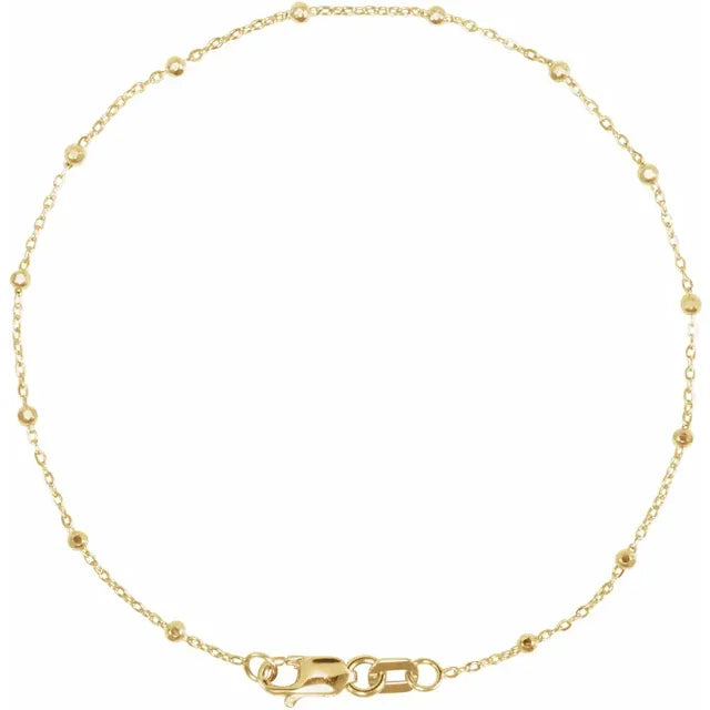 A gold-colored bracelet featuring a series of faceted beads strung on a cable chain.