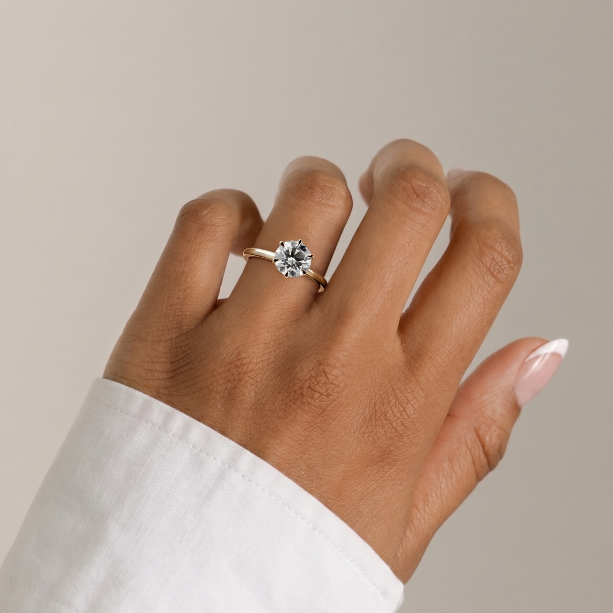 Model wearing a diamond ring on a neutral background