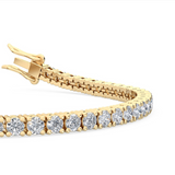 Detail close up of four-claw setting holding round diamond in polished yellow gold