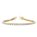A four claw tennis bracelet set with round brilliant cut diamonds, in a gold color, against a white background.