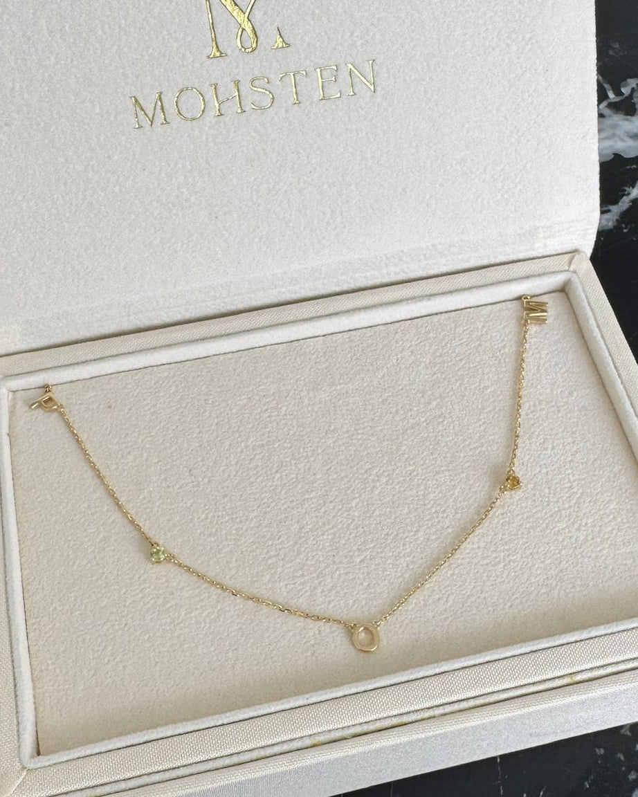 Gold necklace in a branded jewelry box on a marble surface