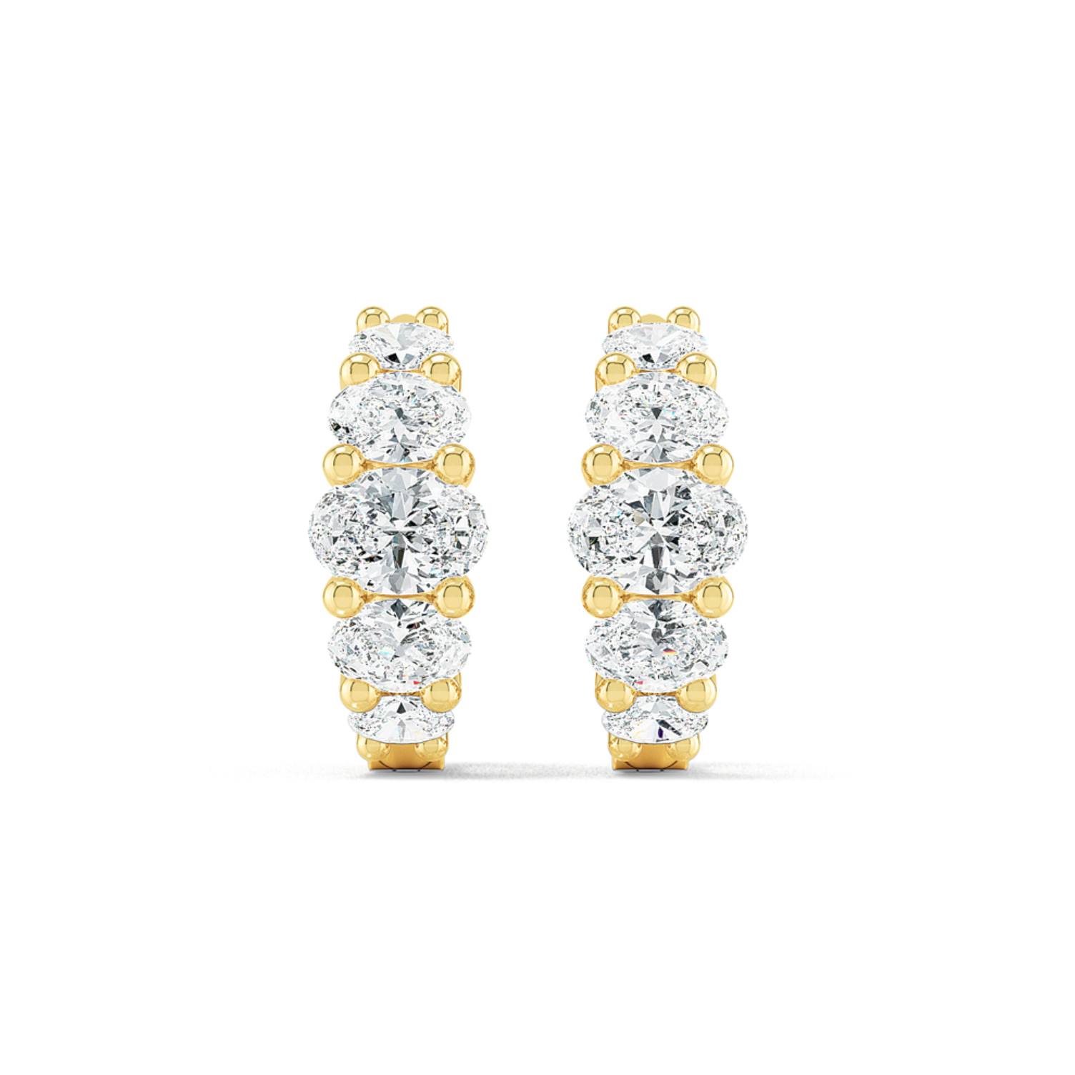 A pair of oval huggie earrings featuring multiple diamond cuts, set in either white or yellow gold.