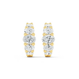 A pair of oval huggie earrings featuring multiple diamond cuts, set in either white or yellow gold.