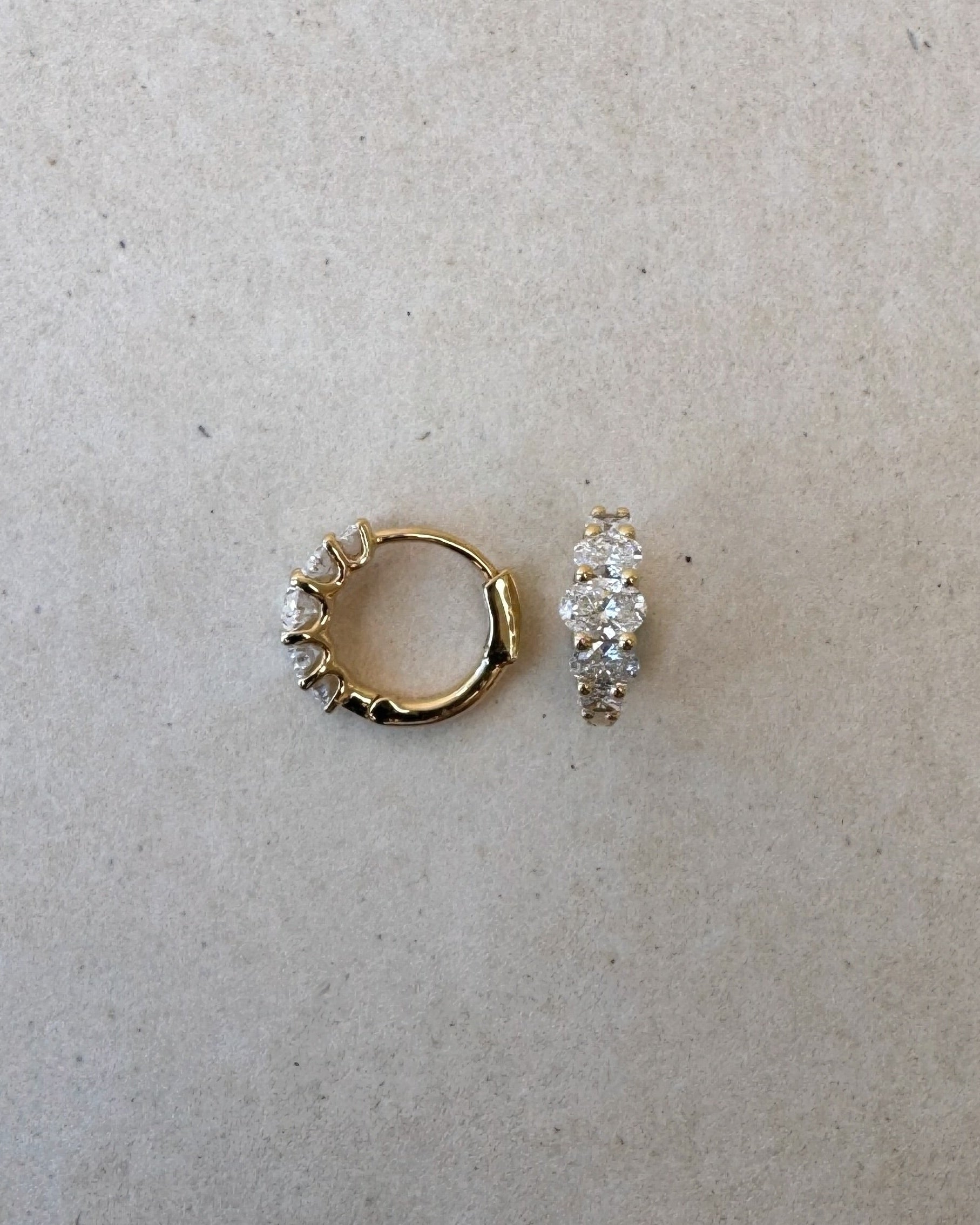 Lucerne Oval Huggies in 18ct gold shown side by side, highlighting symmetry and oval diamond layout