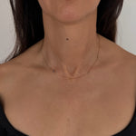 MOHSTEN mini personalised 9ct gold charm necklace featuring custom initials and birthstones, modeled on a woman's neck.