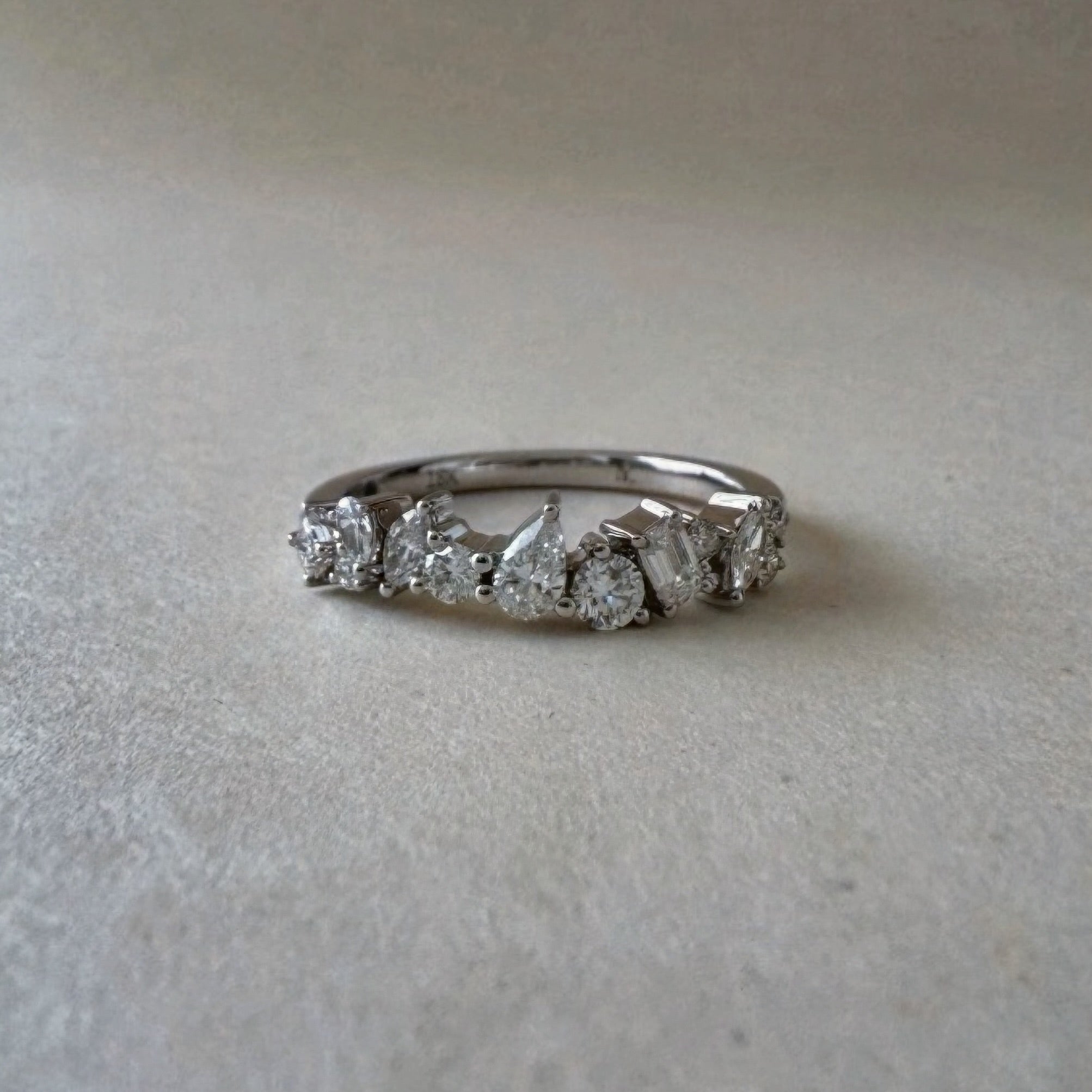 Diamond ring with a white gold band on a light grey background