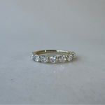 Gold ring with diamonds on a light gray background