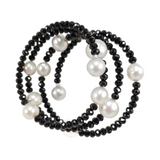Black beaded necklace with white pearls on a white background