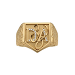 Gold signet ring with decorative design and embedded stones on a white background
