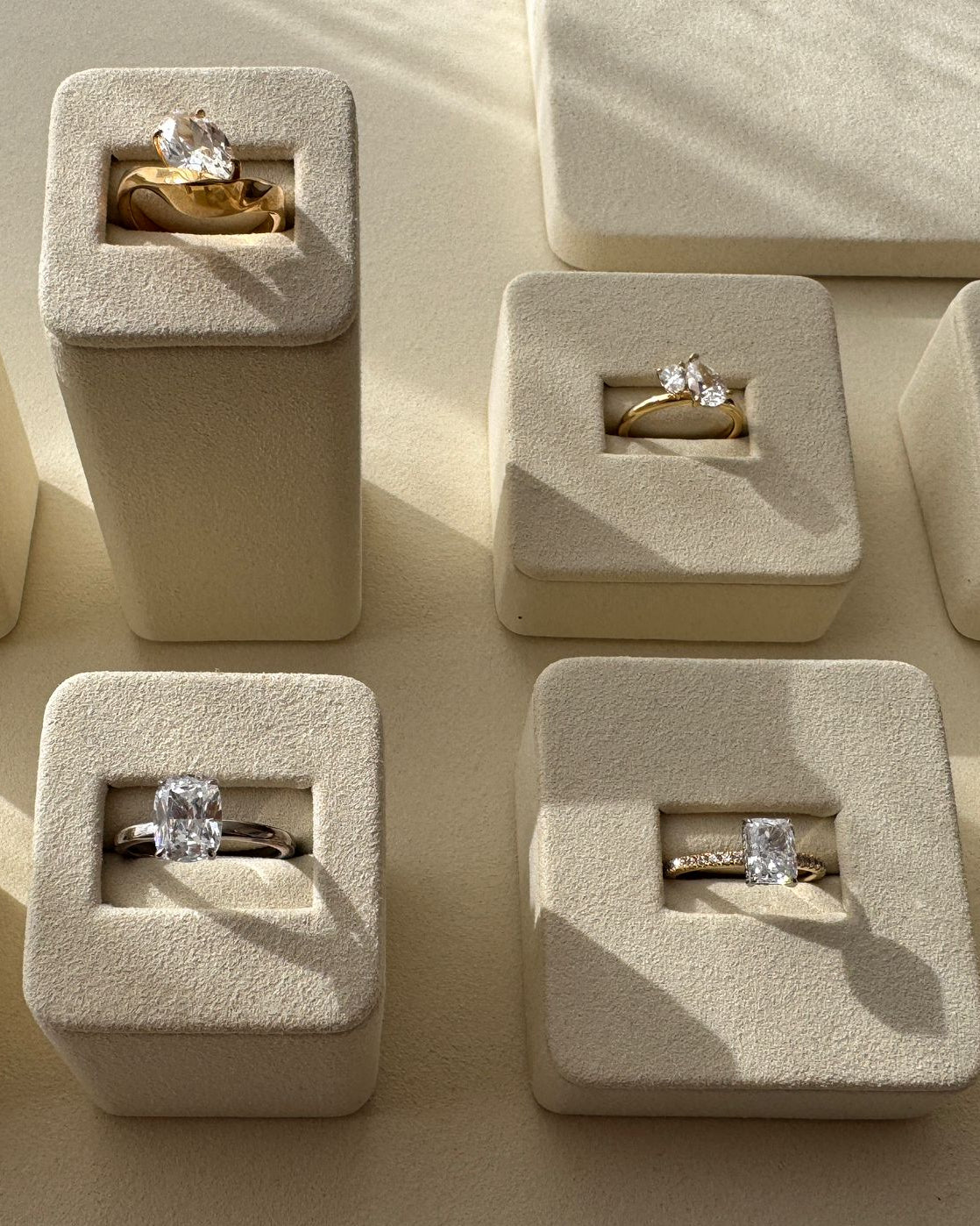 Multiple diamond rings in small beige boxes on display