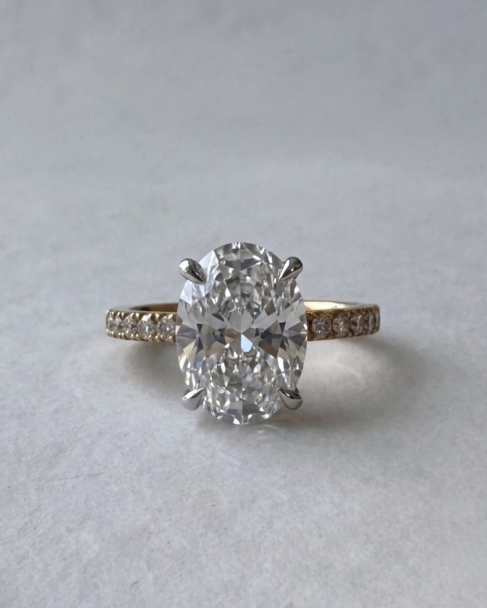 Close-up view of the MOHSTEN Aspen oval diamond engagement ring in 18ct yellow gold showcasing the elongated oval brilliant centre stone and shared-claw diamond band.