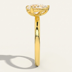Side profile view of the MOHSTEN Cairo pear diamond Toi et Moi engagement ring in 18ct yellow gold, showcasing the low-profile setting architecture and elegant shadow on a minimalist studio background.