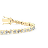Close-up of smooth bezel settings and round diamonds on polished gold links in bracelet