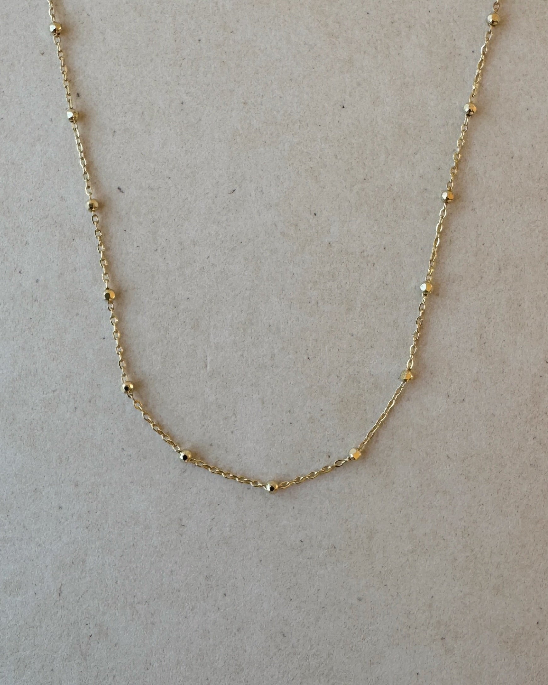 Close-up of Beaded Cable Necklace in 14ct gold showing faceted bead detail
