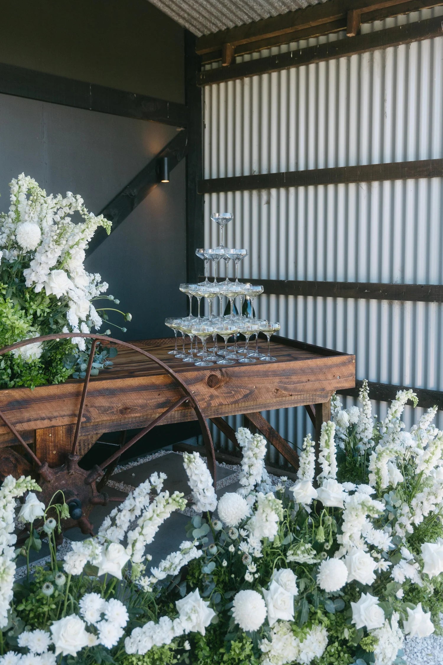 MOHSTEN wedding decorative setup with flowers and a wooden cart in an indoor setting.
