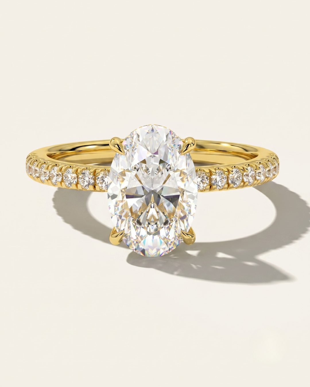 MOHSTEN Aspen oval diamond solitaire engagement ring in 18ct yellow gold showcasing an elongated oval brilliant centre stone and a fluid scalloped diamond-set band.