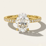 MOHSTEN Aspen oval diamond solitaire engagement ring in 18ct yellow gold showcasing an elongated oval brilliant centre stone and a fluid scalloped diamond-set band.