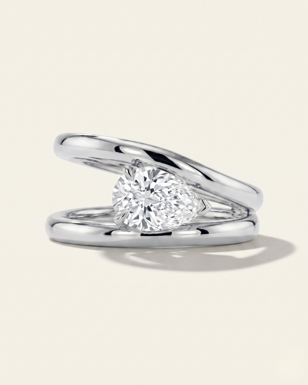 MOHSTEN Beaufort pear diamond double band engagement ring in polished platinum showcasing an east-west oriented pear diamond floating within an architectural split band.
