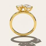 MOHSTEN Cairo pear diamond Toi et Moi engagement ring in 18ct yellow gold from a standing side-profile view, highlighting the circular band and low-profile prong setting architecture casting a sharp architectural shadow.