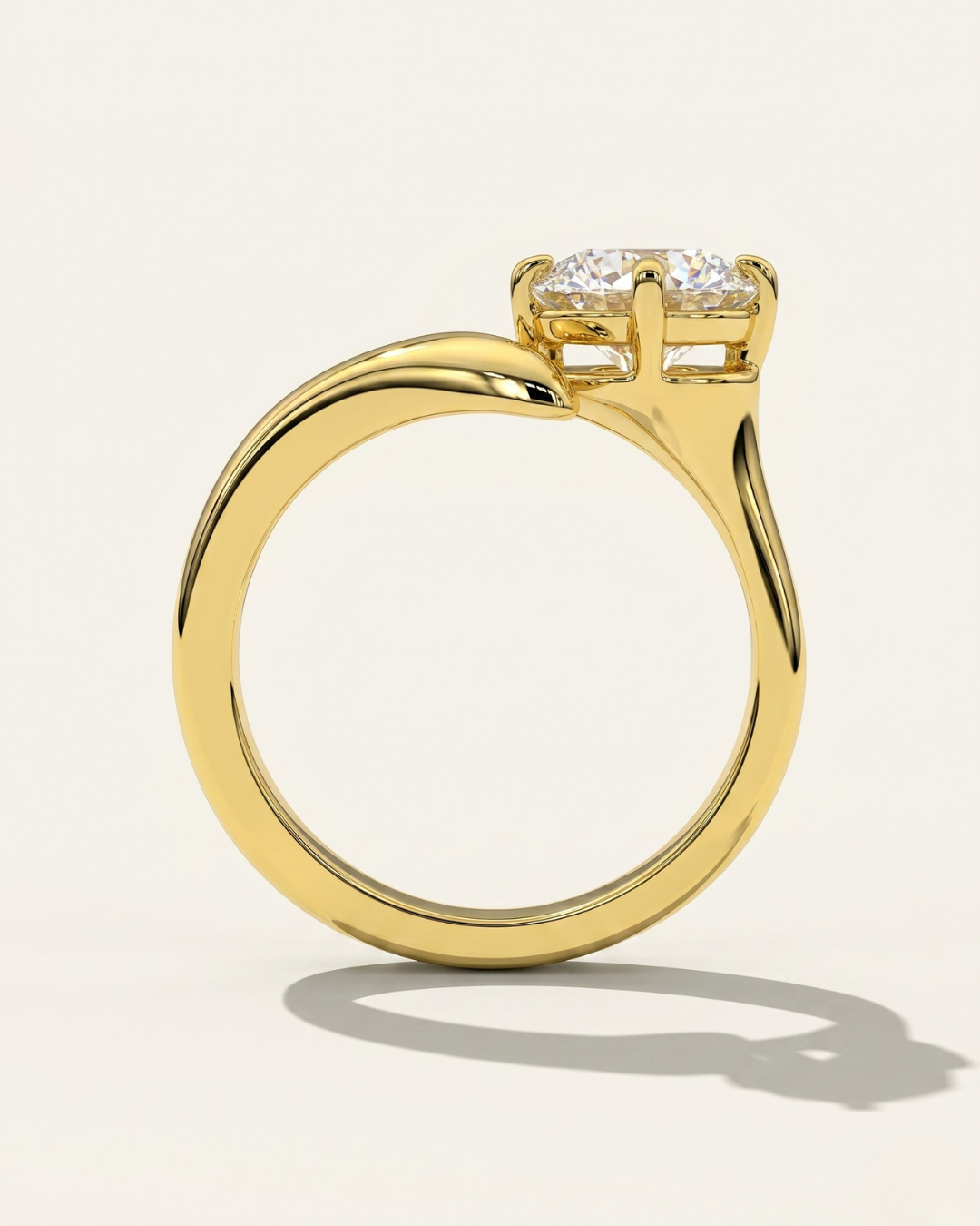 Through-finger circular profile view of the MOHSTEN Granada asymmetric round diamond solitaire engagement ring in 18ct yellow gold, highlighting the clean inner band geometry and the unique low-profile setting architecture casting a crisp studio shadow.