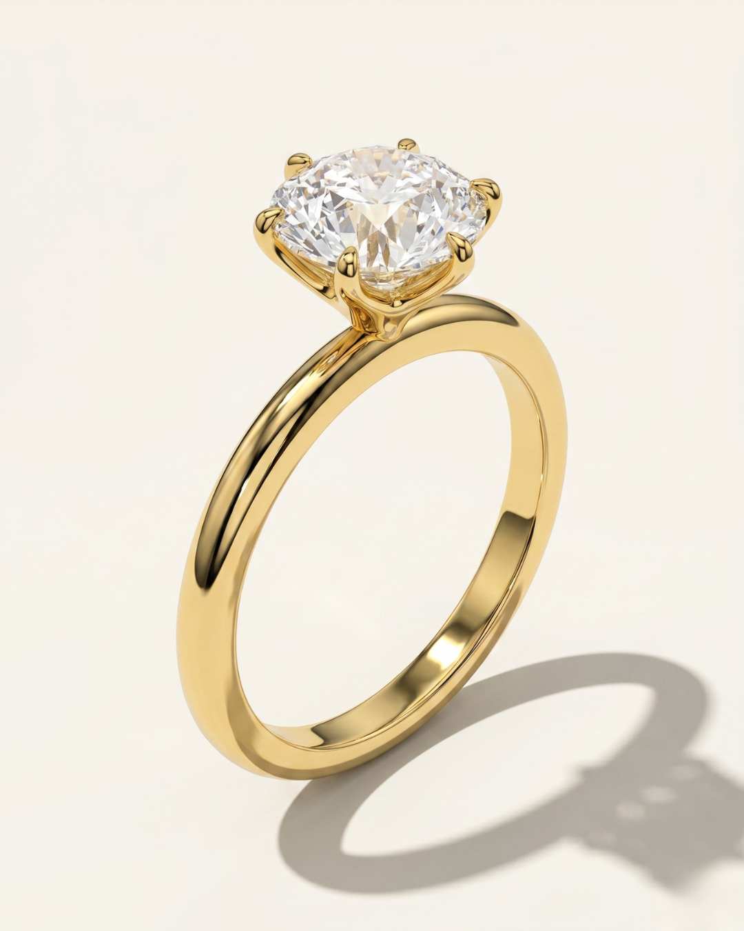 An angled three-quarter studio view of the MOHSTEN Jaipur round diamond solitaire engagement ring in 18ct yellow gold, highlighting the high-polish comfort-fit band and the structural 6-prong setting architecture.