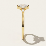 MOHSTEN Montreux 18ct yellow gold three-stone engagement ring back profile with half-bezel emerald cut diamond.