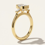MOHSTEN Montreux 18ct yellow gold three-stone engagement ring side profile with emerald cut diamond and knife-edge band.