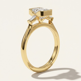 MOHSTEN Montreux 18ct yellow gold three-stone engagement ring side profile with emerald cut diamond and knife-edge band.