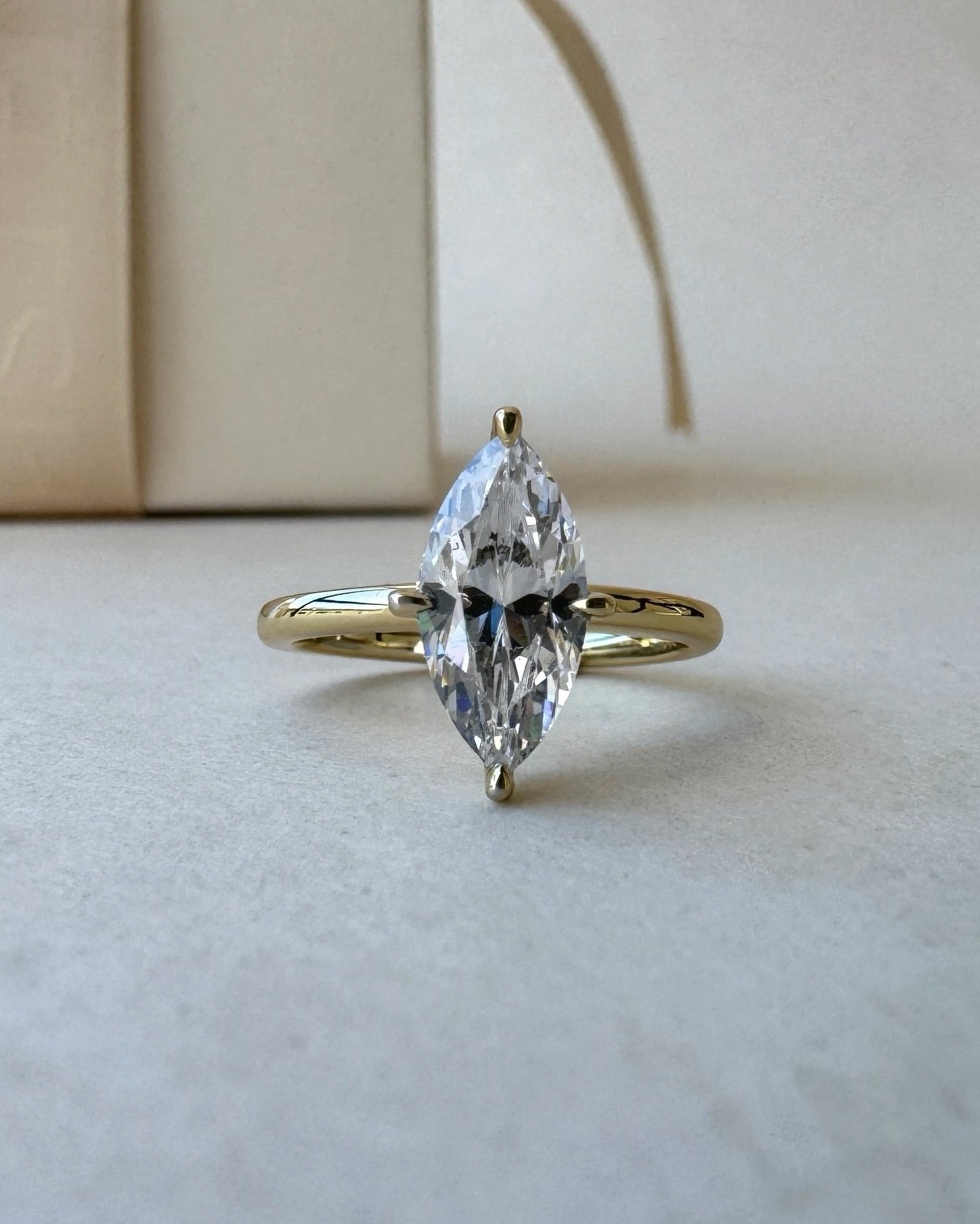 MOHSTEN Niseko diamond engagement ring in 18ct yellow gold featuring a solitaire marquise cut centre stone with protective prongs. ring with packaging