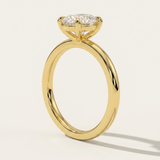 MOHSTEN Osaka oval diamond solitaire engagement ring in 18ct yellow gold from a direct side profile standing view, highlighting the architectural 4-prong basket setting and its elegant shadow on a minimalist studio background.
