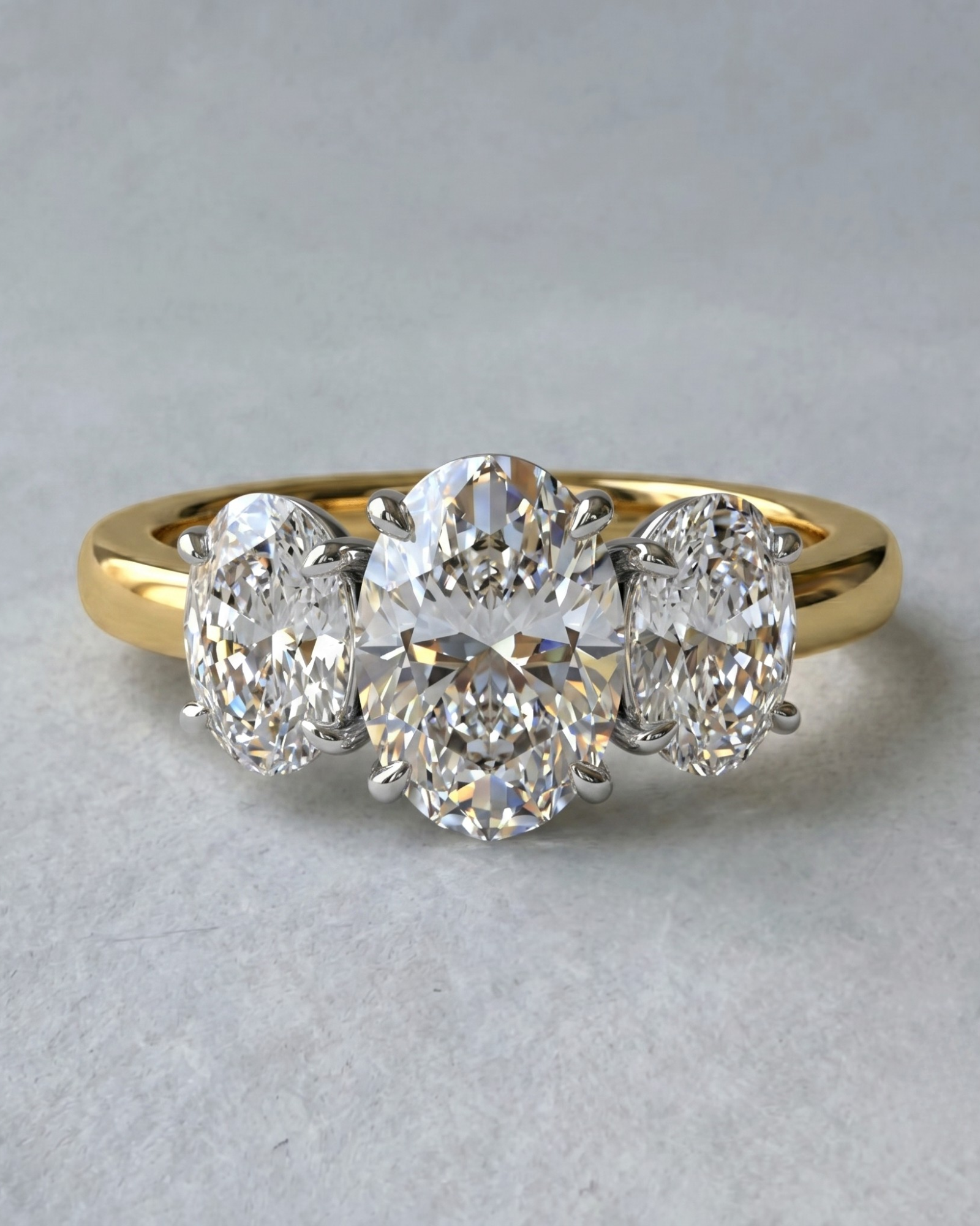 MOHSTEN Sydney oval diamond trilogy engagement ring in 18ct yellow gold showcasing a premium central oval diamond flanked symmetrically by two matching oval side stones.