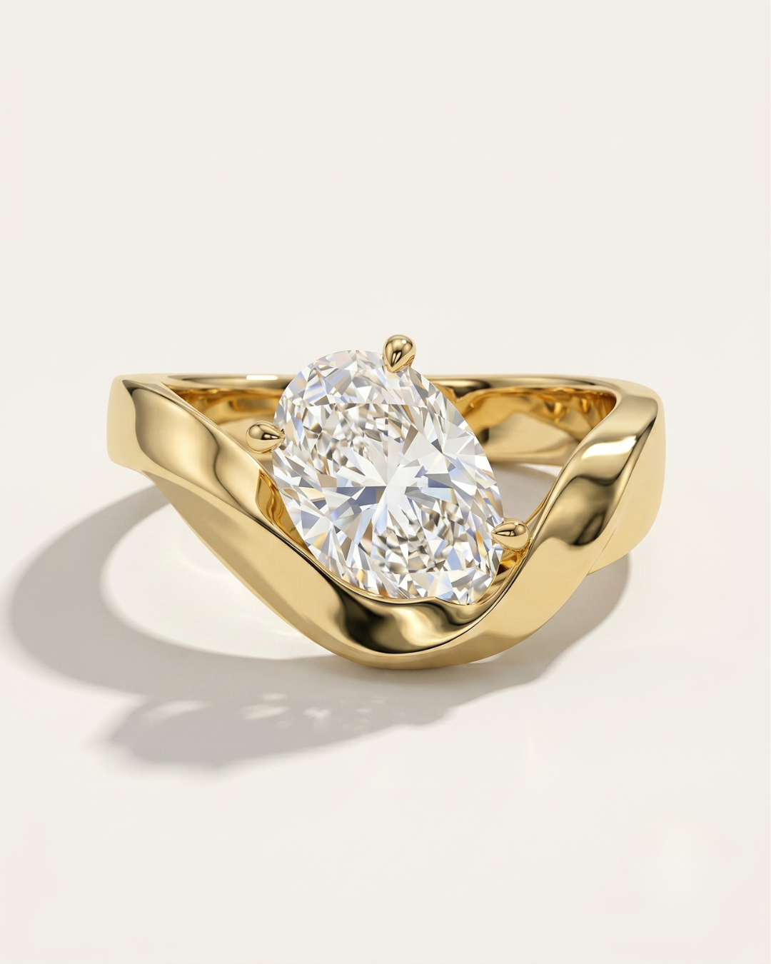 MOHSTEN Tairua oval diamond solitaire engagement ring in 18ct yellow gold showcasing an angled oval centre diamond in a sweeping bypass ribbon-like band setting.