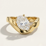 MOHSTEN Tairua oval diamond solitaire engagement ring in 18ct yellow gold showcasing an angled oval centre diamond in a sweeping bypass ribbon-like band setting.