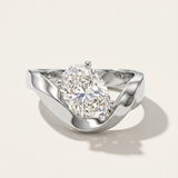MOHSTEN Tairua oval diamond solitaire engagement ring in polished platinum showcasing an asymmetric, organically angled oval centre diamond nestled in a fluid bypass ribbon band.
