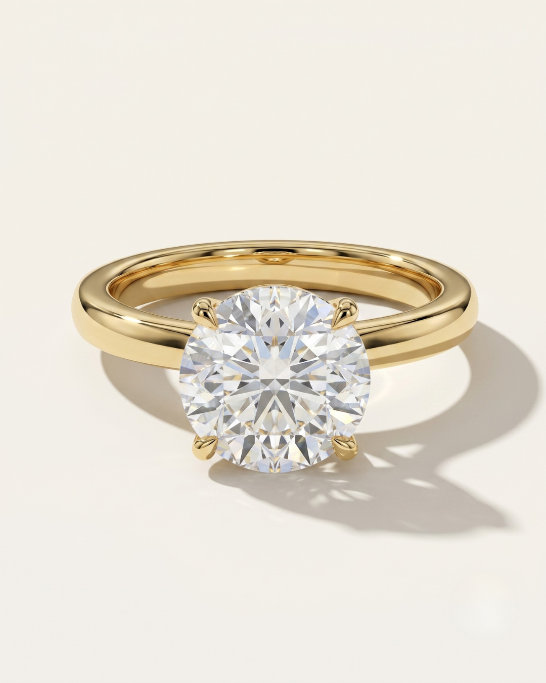 MOHSTEN Uluwatu round diamond solitaire engagement ring in 18ct yellow gold showcasing a premium round brilliant centre stone in a minimalist 4-prong basket setting.