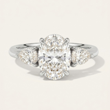MOHSTEN Valencia oval and pear diamond trilogy engagement ring in polished platinum showcasing an elongated oval centre diamond and two sharp pear-cut side stones.
