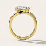 MOHSTEN Venice pear diamond solitaire engagement ring in 18ct yellow gold from a through-finger circular profile view, highlighting the polished round band and the low-profile setting architecture casting a crisp shadow.