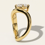 Side profile view of the MOHSTEN Venice pear diamond solitaire engagement ring in 18ct yellow gold, showcasing the unique low-profile setting and fluid, sweeping band architecture casting a distinct shadow on a light studio background.